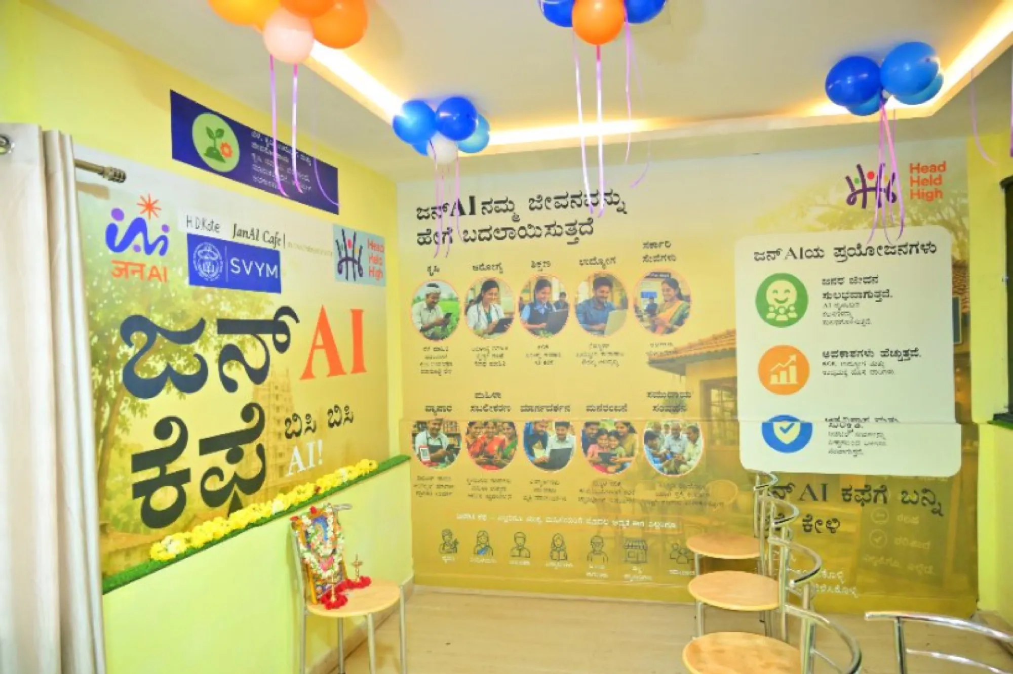 Inside a JanAI Cafe: bright walls with scheme posters in Kannada and seating for visitors